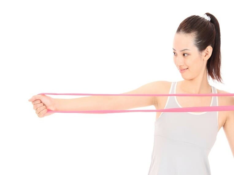 Jeune femme tenant un elastique de musculation