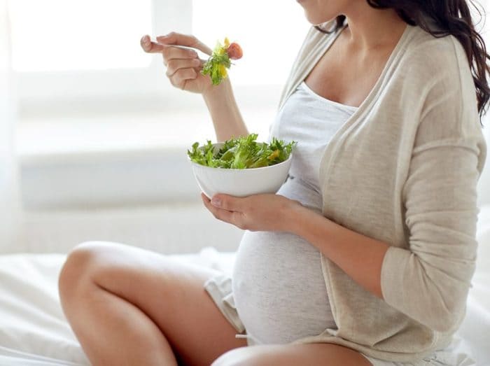 Jeune femme enceinte dégustant une salade