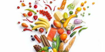 régime Atkins Fruits, légumes, produits laitiers et poissons éparpillés sur un fond blanc