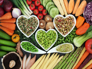 régime Dukan Bols en forme de coeur contenant des graines disposés au milieu de fruits et légumes