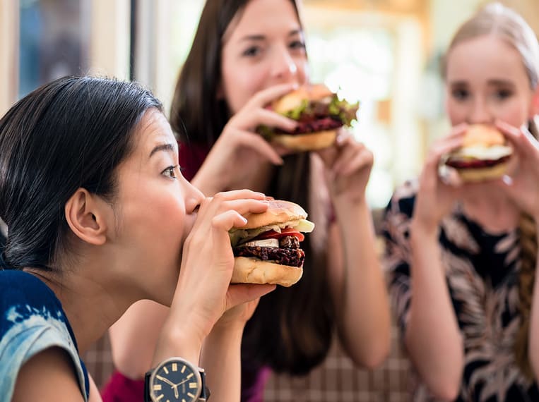 Maigrir vite Jeunes femmes dégustant des hamburger
