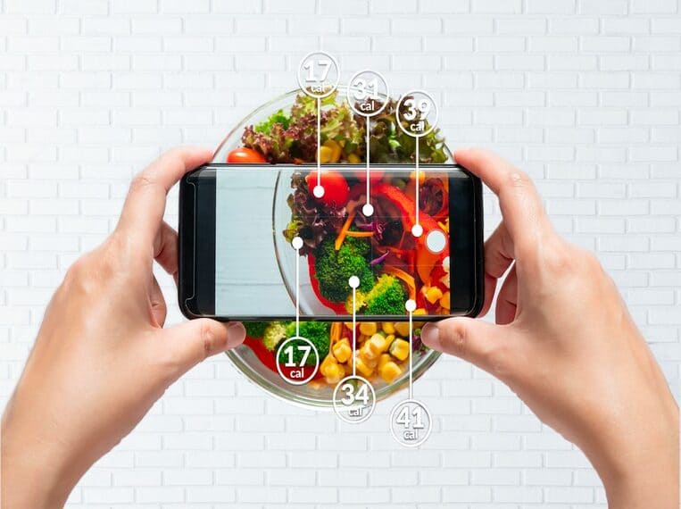 Weight Watchers Smartphone calculant les calories de chaque aliment disposés dans un plat