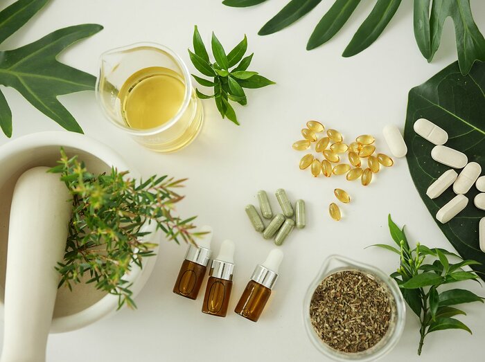 Plantes, gélules et huiles disposés aléatoirement sur une table 