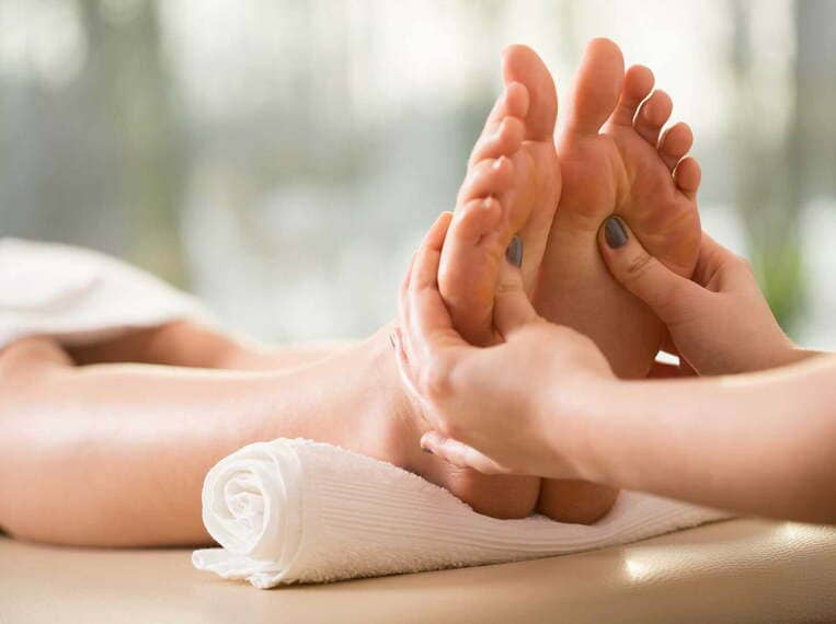 Réflexologie Jeune femme se faisant masser les pieds