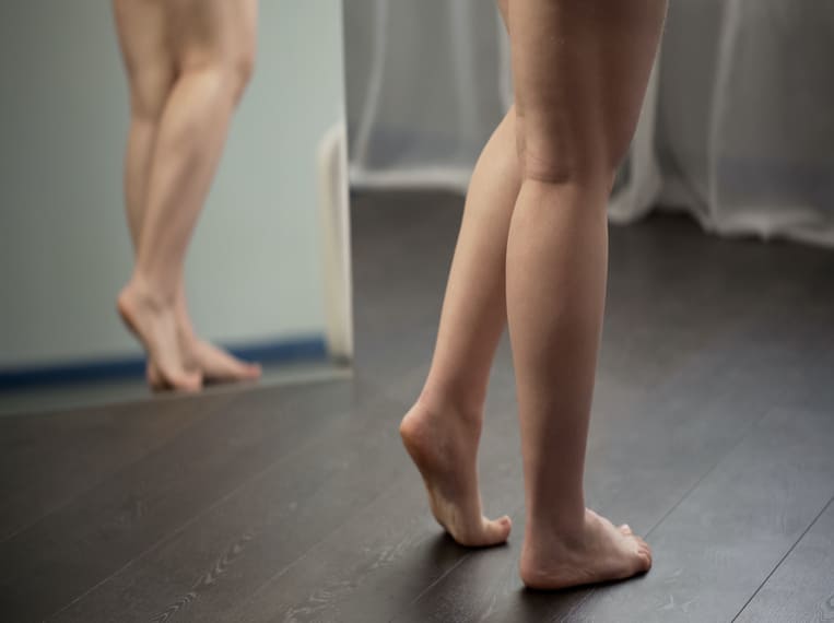 Rétention d’eau Jeune femme constatant ses jambes gonflées dans le miroir