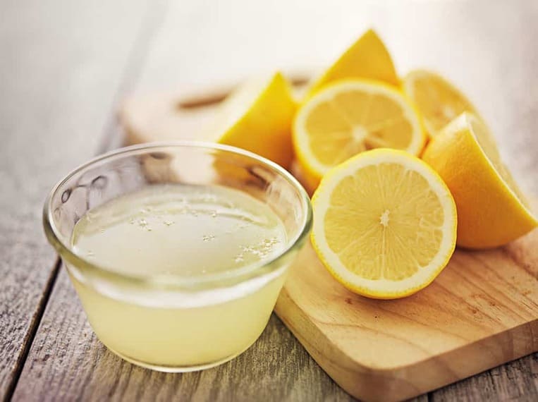 Rétention d’eau Jus de citron dans une coupelle posée au milieu de citrons découpés