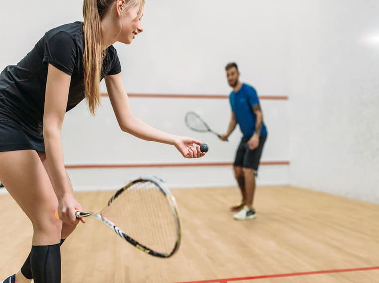 Sport Jeune homme et jeune femme pratiquant le squash