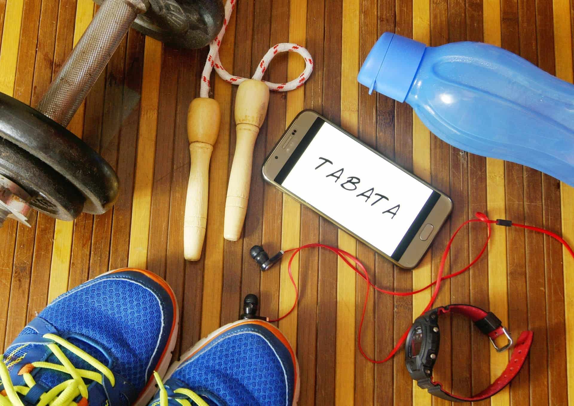 Des baskets, une corde à sauter, des écouteurs, une gourde et un téléphone posés les uns à côté des autres au sol
